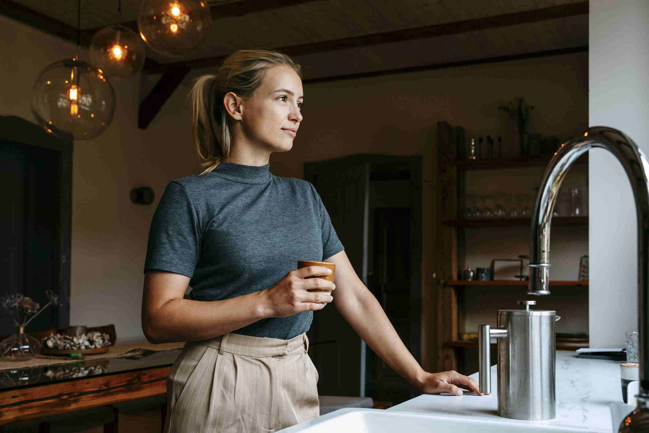 A woman drinking coffee in rental property in Germany.